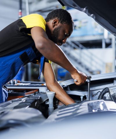 mechanic fixes car fuel tank in garage